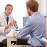 Male Patient Having Consultation With Doctor In Office