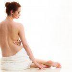 Sitting naked woman in white towel