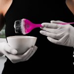 girl in white rubber protective gloves holding a brush in her ha